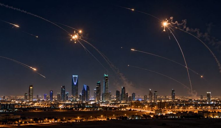 Silueta urbana saudí bajo un cielo nocturno con defensas aéreas interceptando proyectiles.